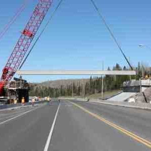 machine suspending large beam over highway