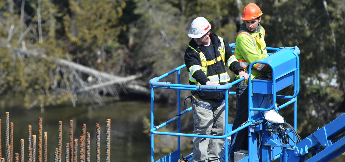 employees on lift inspecting rebar